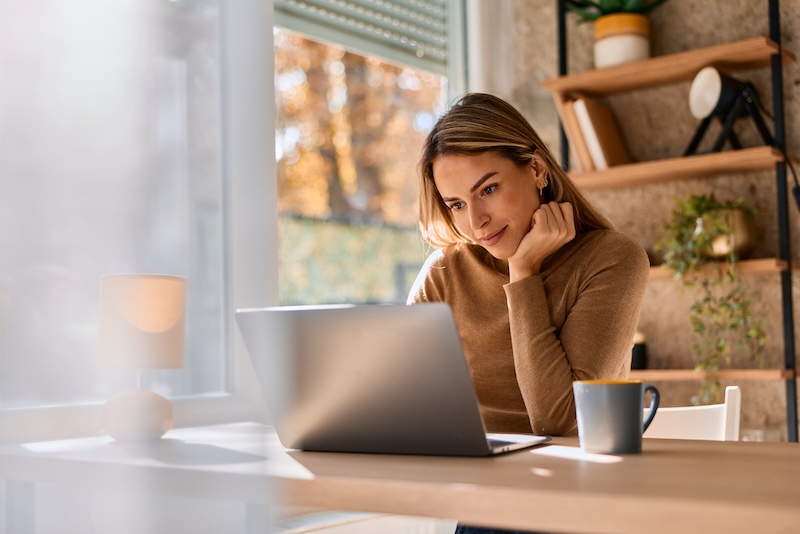 A woman researches common savings account FAQs to ask before applying for a new account.