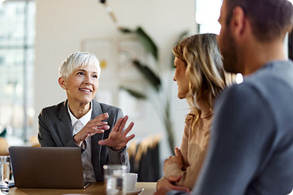 Three people sitting at a round table having a discussion