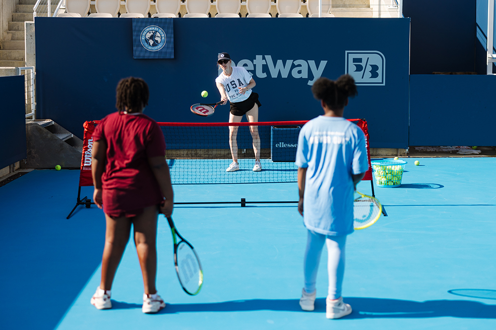 image of two youth playing against one tennis player 