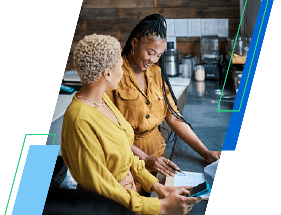 Two women standing at a counter talking in a kitchen
